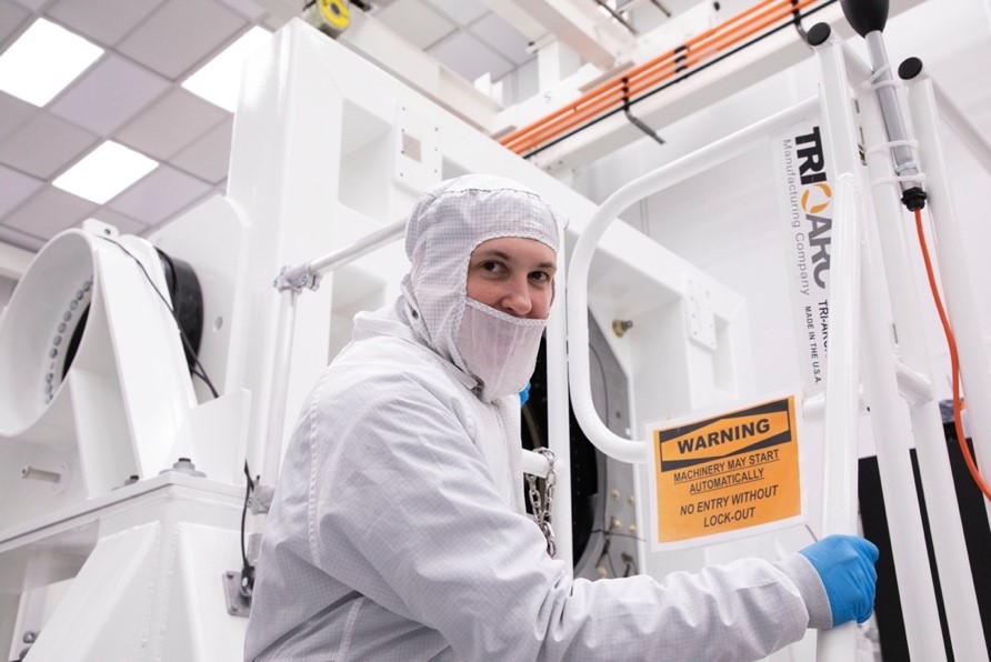 Photo de Claire Juramy-Gilles en tenue de protection, travaillant auprès du télescope LSST