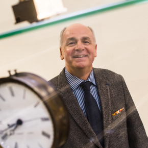 Portrait de Jean Schihin devant une horloge.